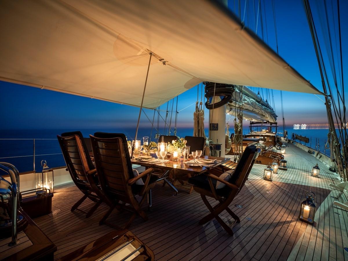 a deck with a table and chairs on it aboard ALEXA OF LONDON Yacht for Sale
