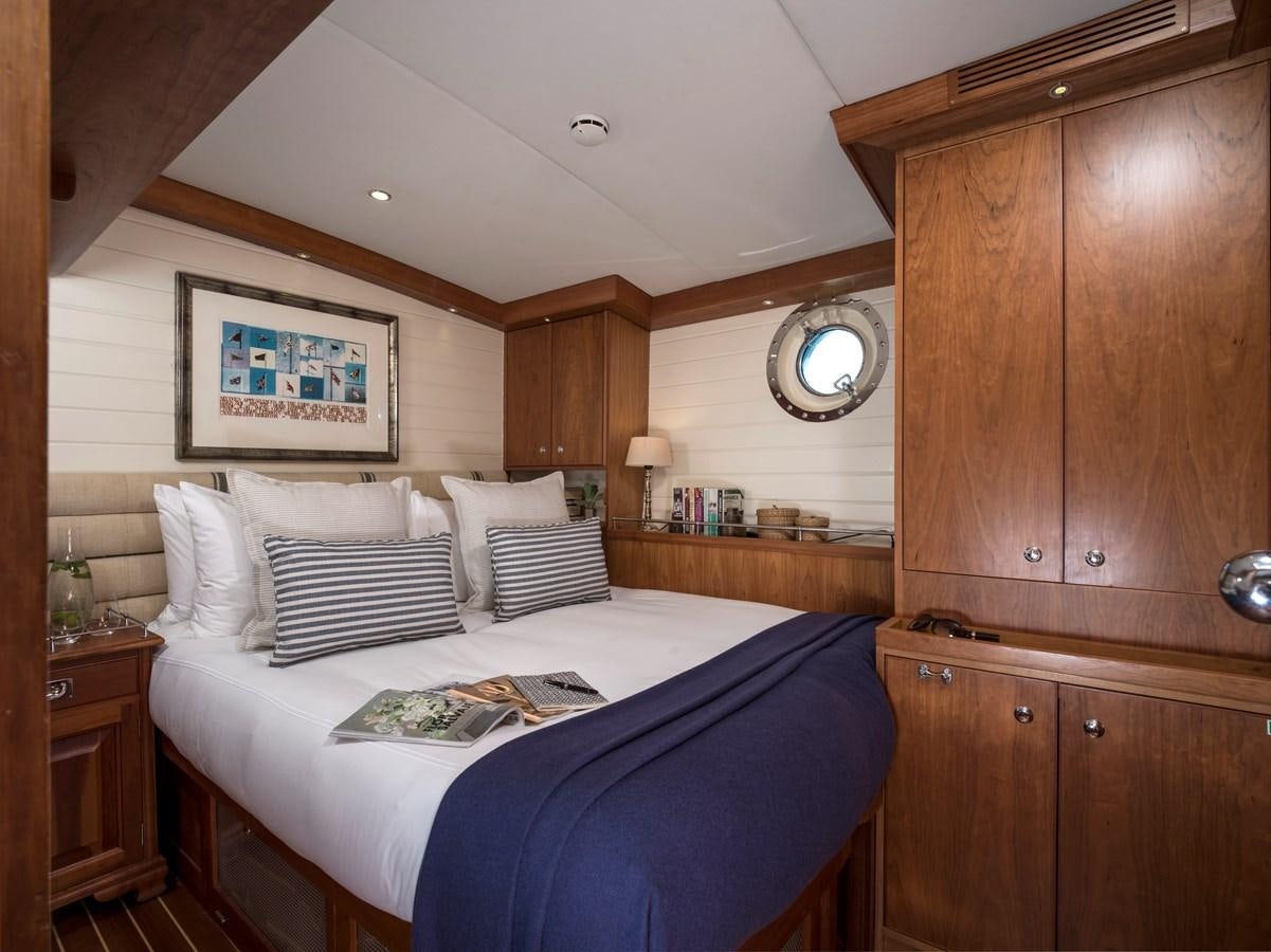 a bedroom with a bed and a dresser aboard ALEXA OF LONDON Yacht for Charter