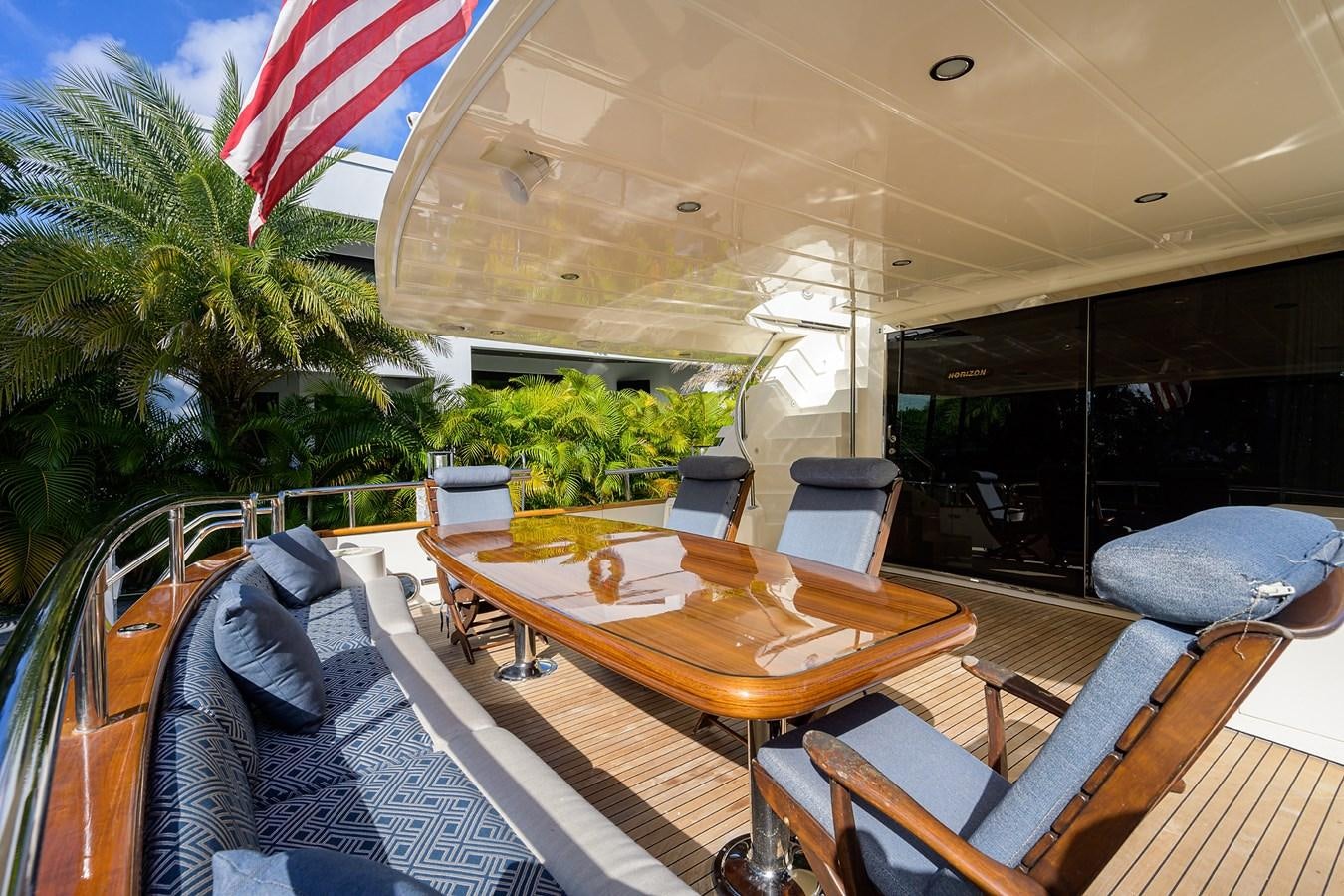 a deck with a table and chairs aboard 82 Yacht for Sale
