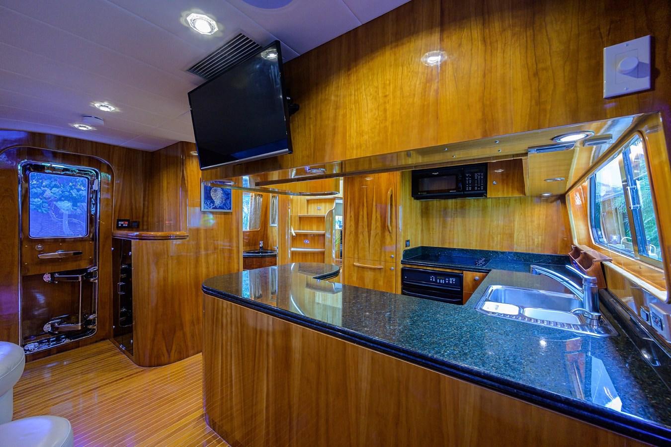 a kitchen with a bar and a tv on the wall aboard 82 Yacht for Sale
