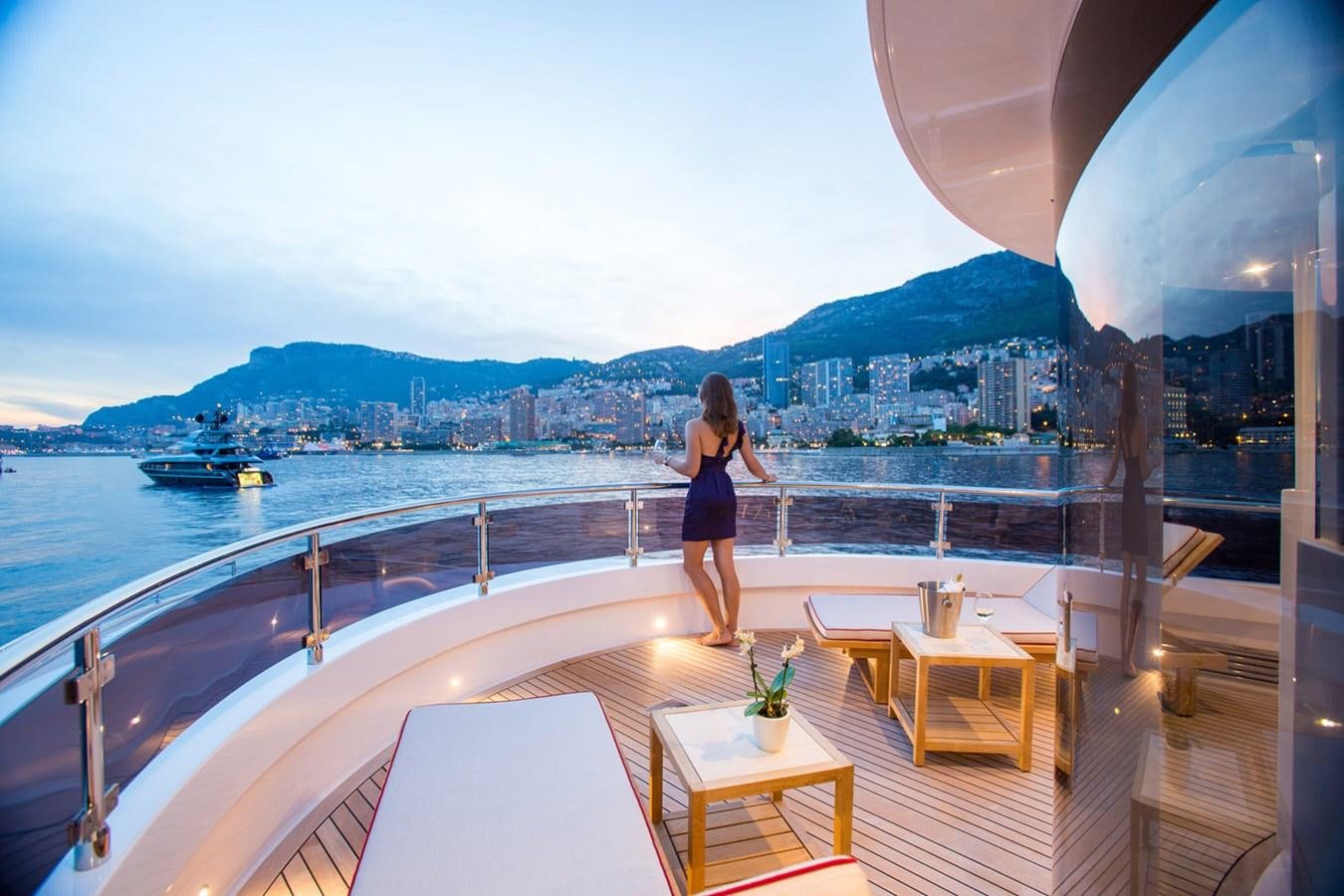 a person standing on a deck overlooking a large body of water aboard GATSBY Yacht for Sale