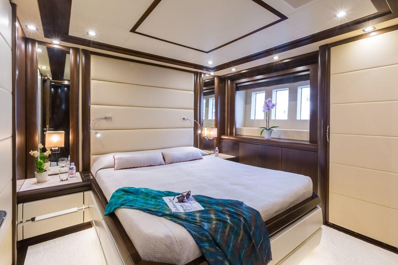 a bedroom with a bed and a mirror aboard GATSBY Yacht for Sale
