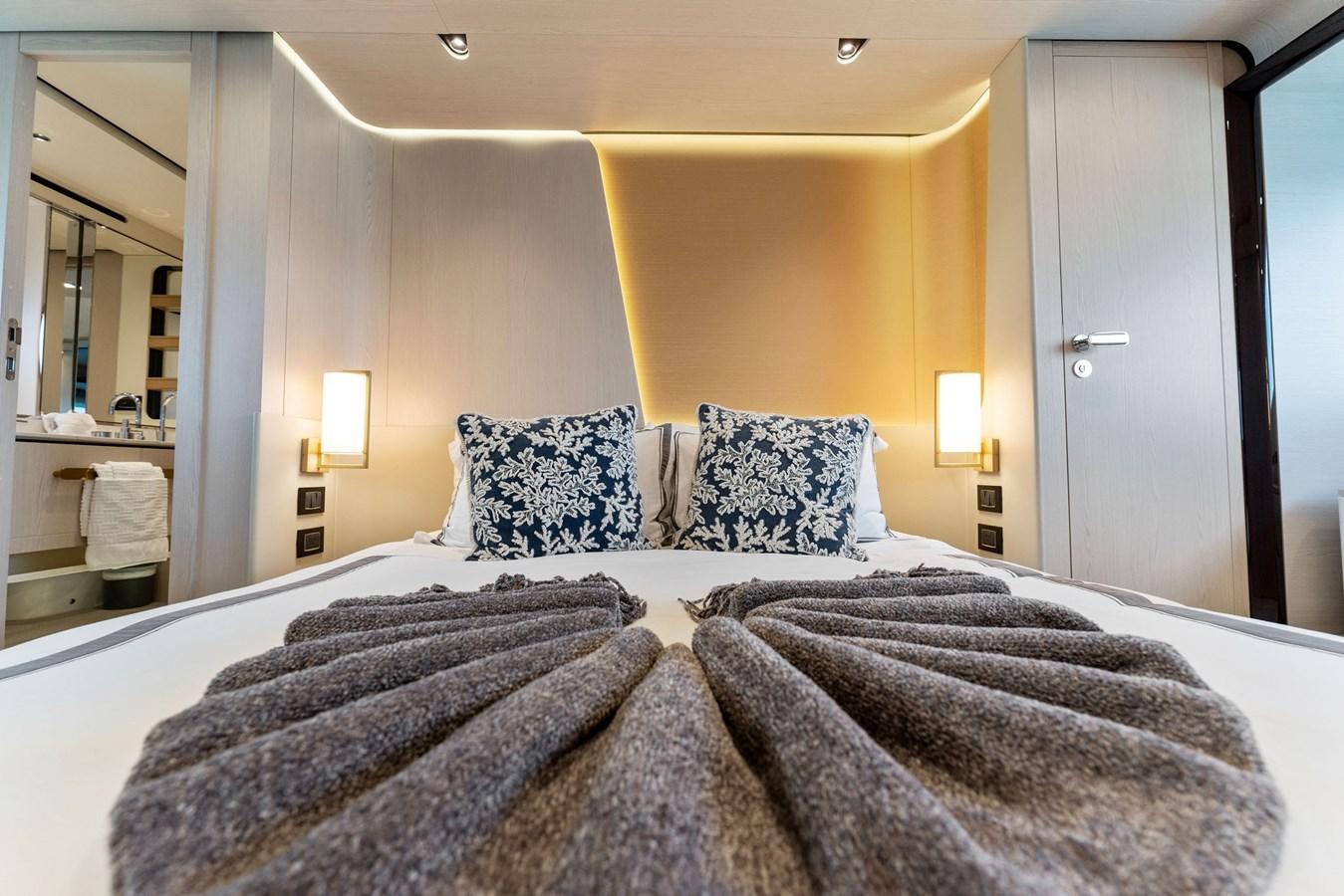 a bed with a black and white bed spread aboard NENA Yacht for Sale