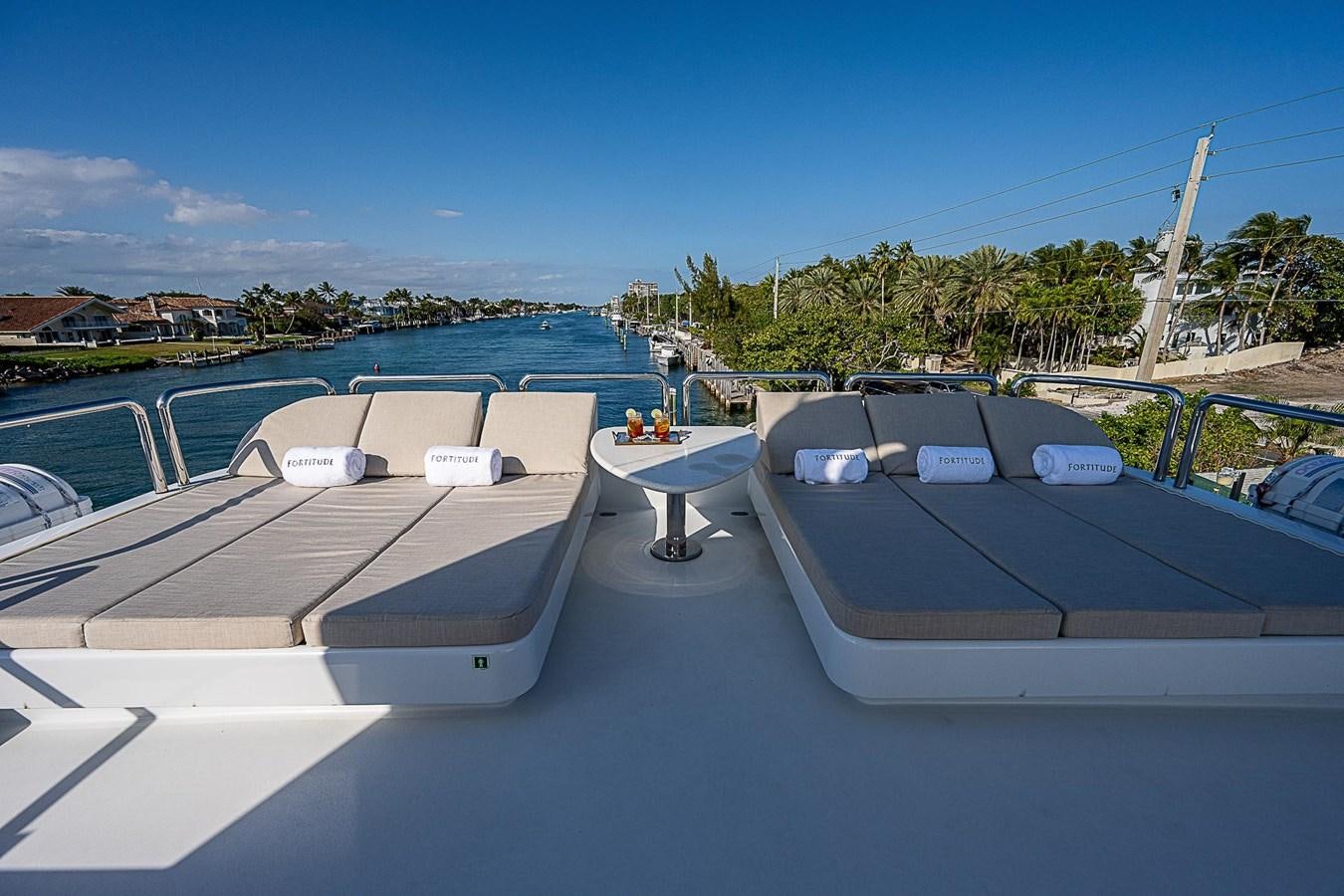 a deck with a pool and a building in the background aboard LAGNIAPPE Yacht for Sale