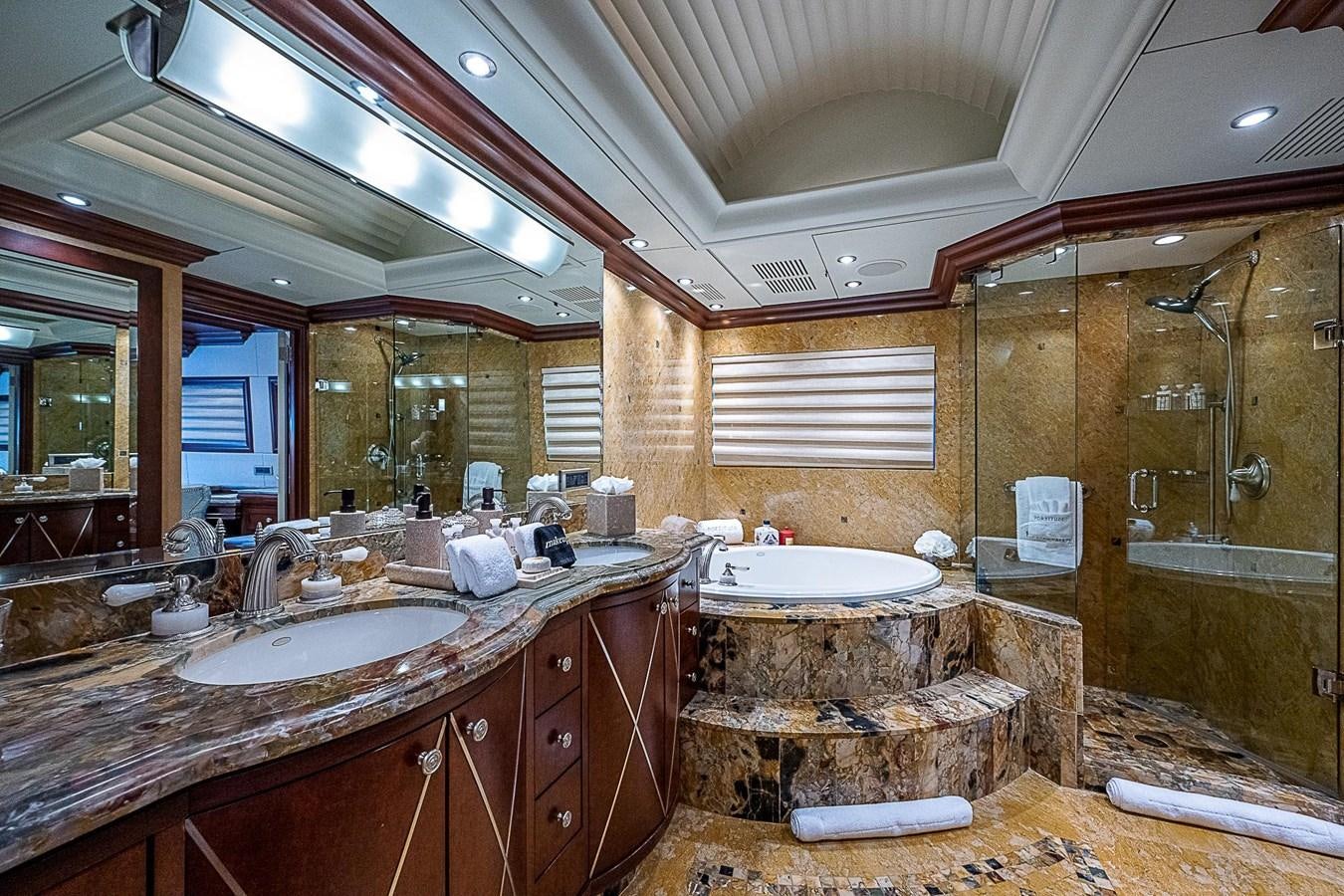 a bathroom with a large marble countertop and a large mirror aboard LAGNIAPPE Yacht for Sale