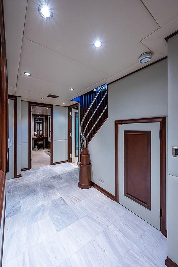 a hallway with a door and a staircase aboard LAGNIAPPE Yacht for Sale