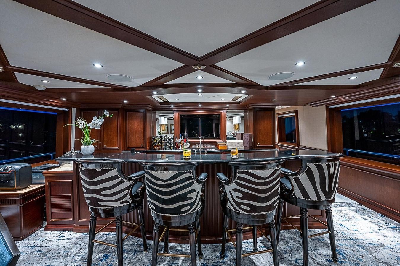 a large kitchen with a bar and chairs aboard LAGNIAPPE Yacht for Sale