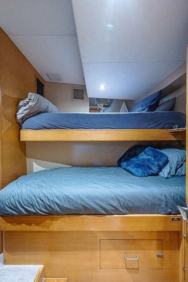 a bed with a blue comforter aboard LAGNIAPPE Yacht for Sale