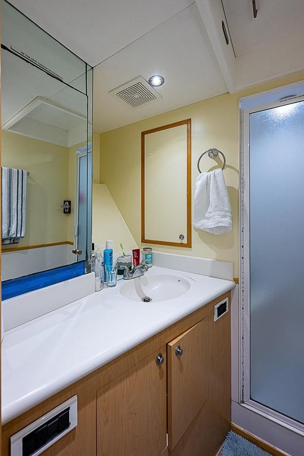 a bathroom with a sink and a mirror aboard LAGNIAPPE Yacht for Sale