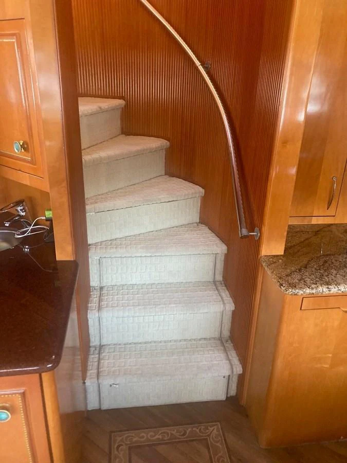 a staircase with a wood railing aboard SIR JON II Yacht for Sale