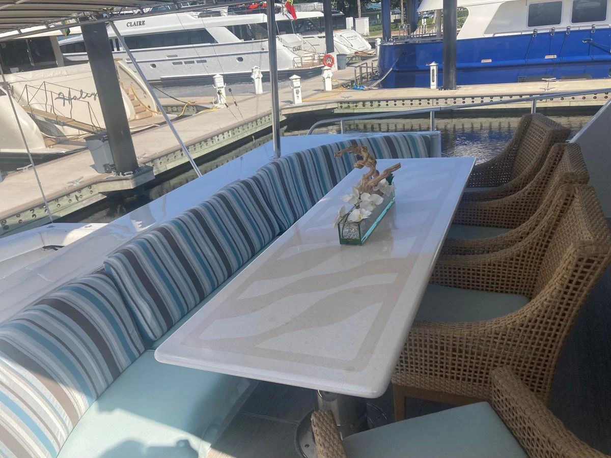 a person sitting on a chair at a table on a boat aboard SIR JON II Yacht for Sale