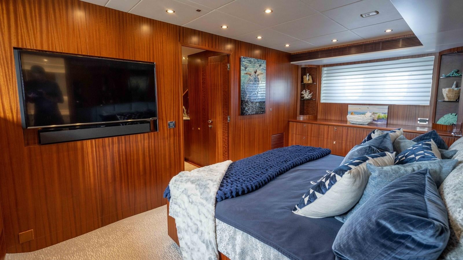 a room with a bed and a television aboard E84 Yacht for Sale