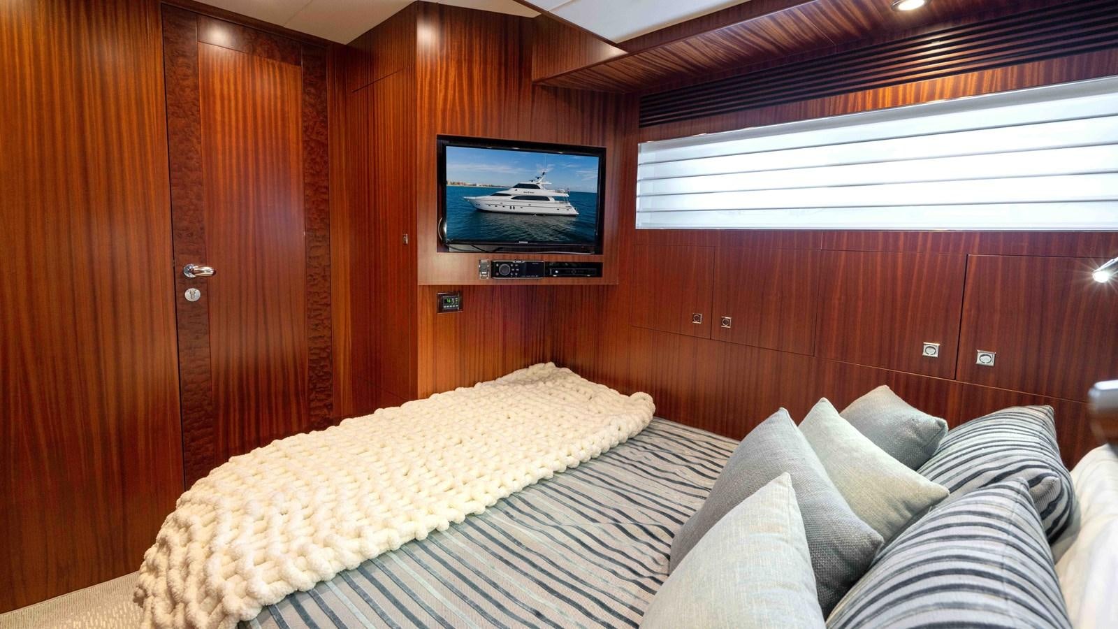 a bed with a television on the wall aboard E84 Yacht for Sale