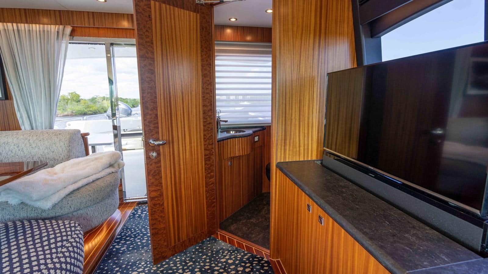 a living room with a wood door aboard E84 Yacht for Sale