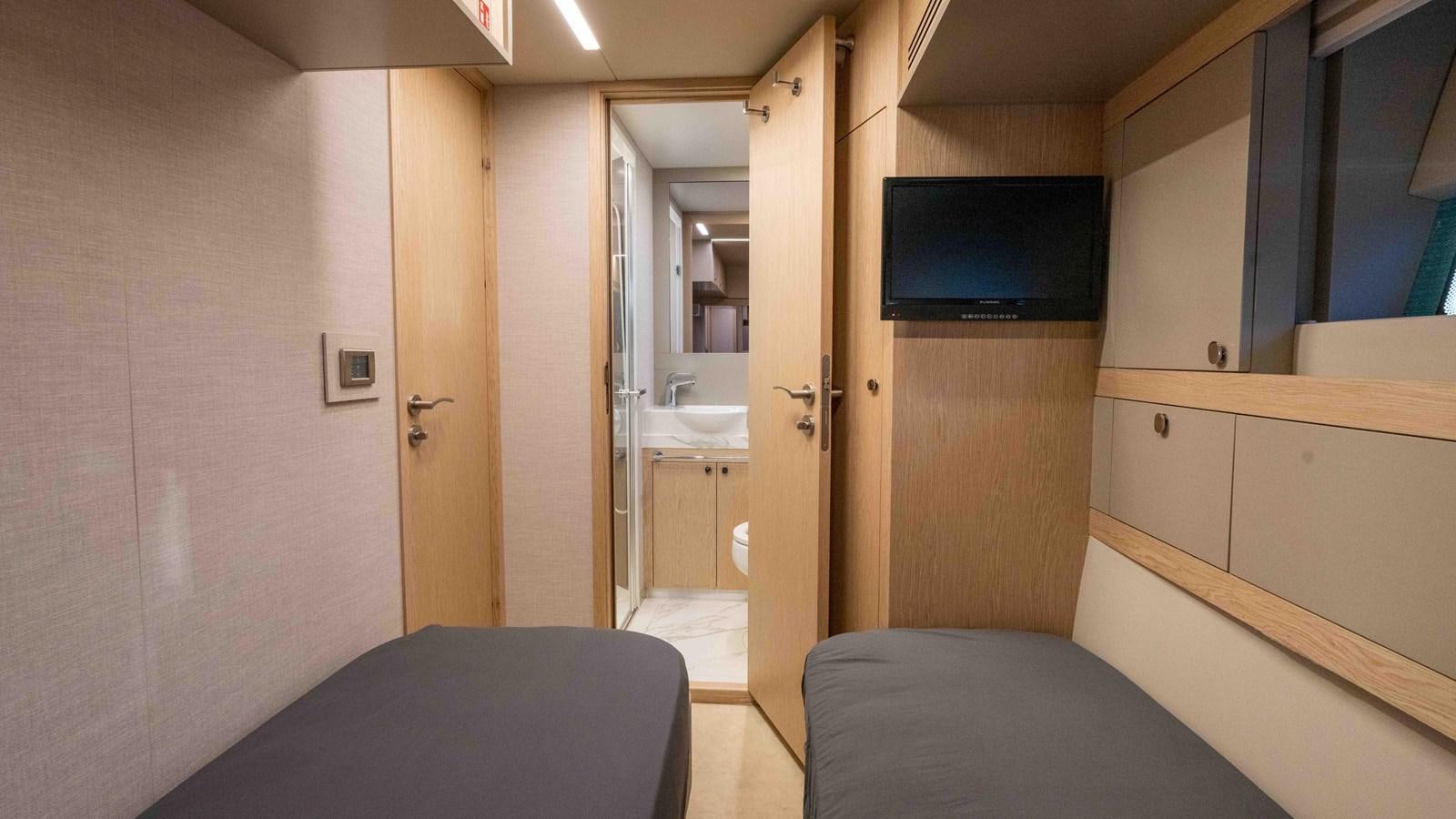 a room with a bed and a tv on the wall aboard ADONIS Yacht for Sale