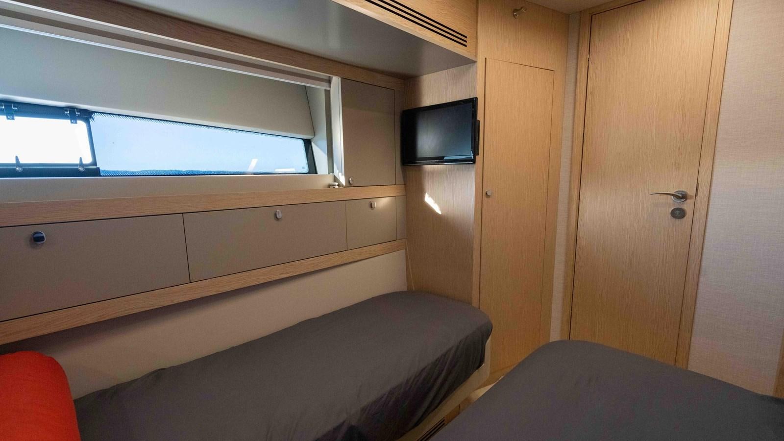 a room with a bed and a television aboard ADONIS Yacht for Sale