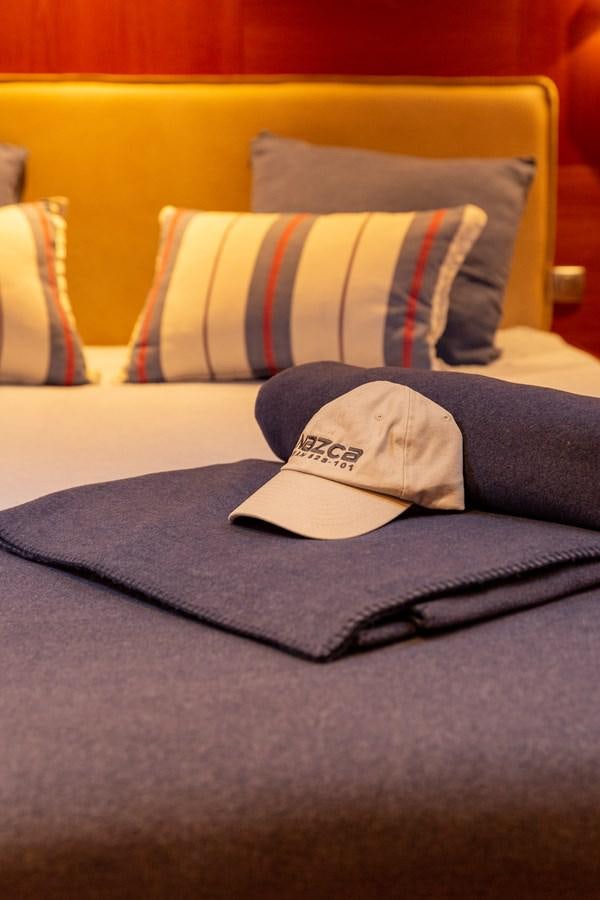 a blue and white pillow on a bed aboard NAZCA 2 Yacht for Sale