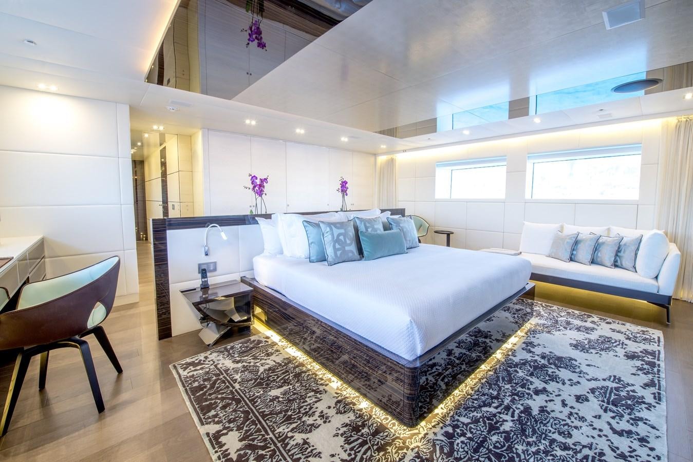 a large bedroom with a bed and a chair aboard AXIOS Yacht for Sale