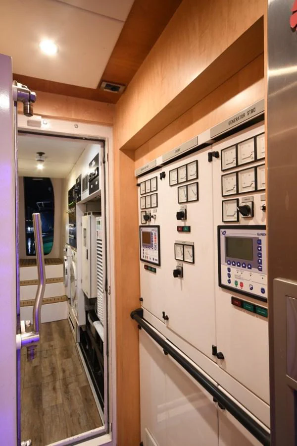 a hallway with a wall of electronic devices and screens aboard KOMOKWA Yacht for Charter