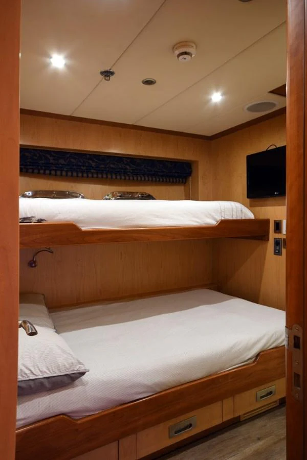 a room with a bed and a television aboard KOMOKWA Yacht for Charter