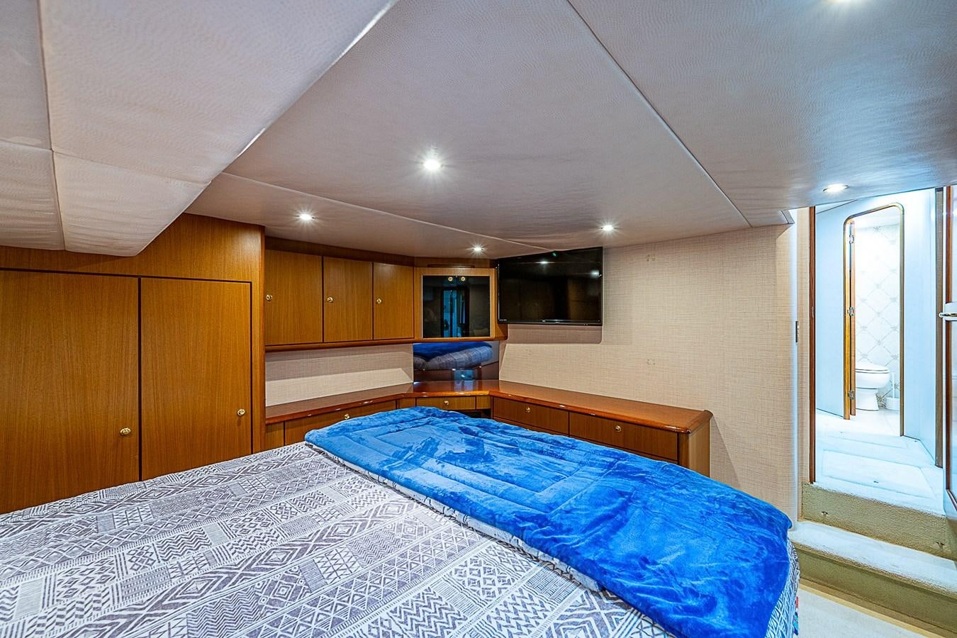 a bedroom with wood cabinets aboard THIS LITTLE PIGGY Yacht for Sale