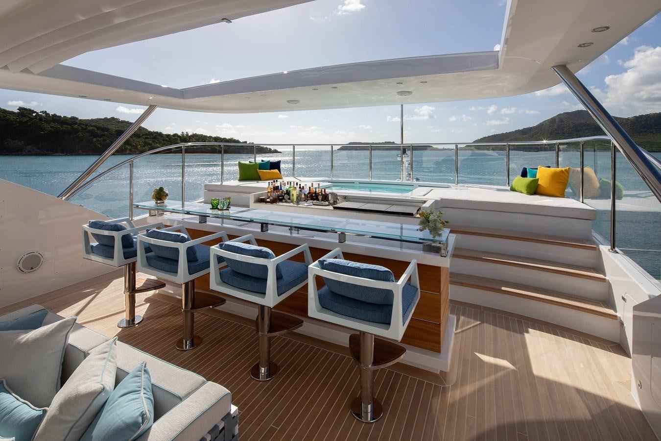 a deck with a pool and a deck with chairs and a table aboard JODI ANN Yacht for Charter