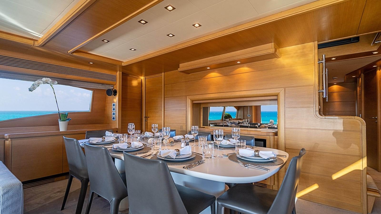 a dining room with a table set for dinner aboard PATRON Yacht for Sale