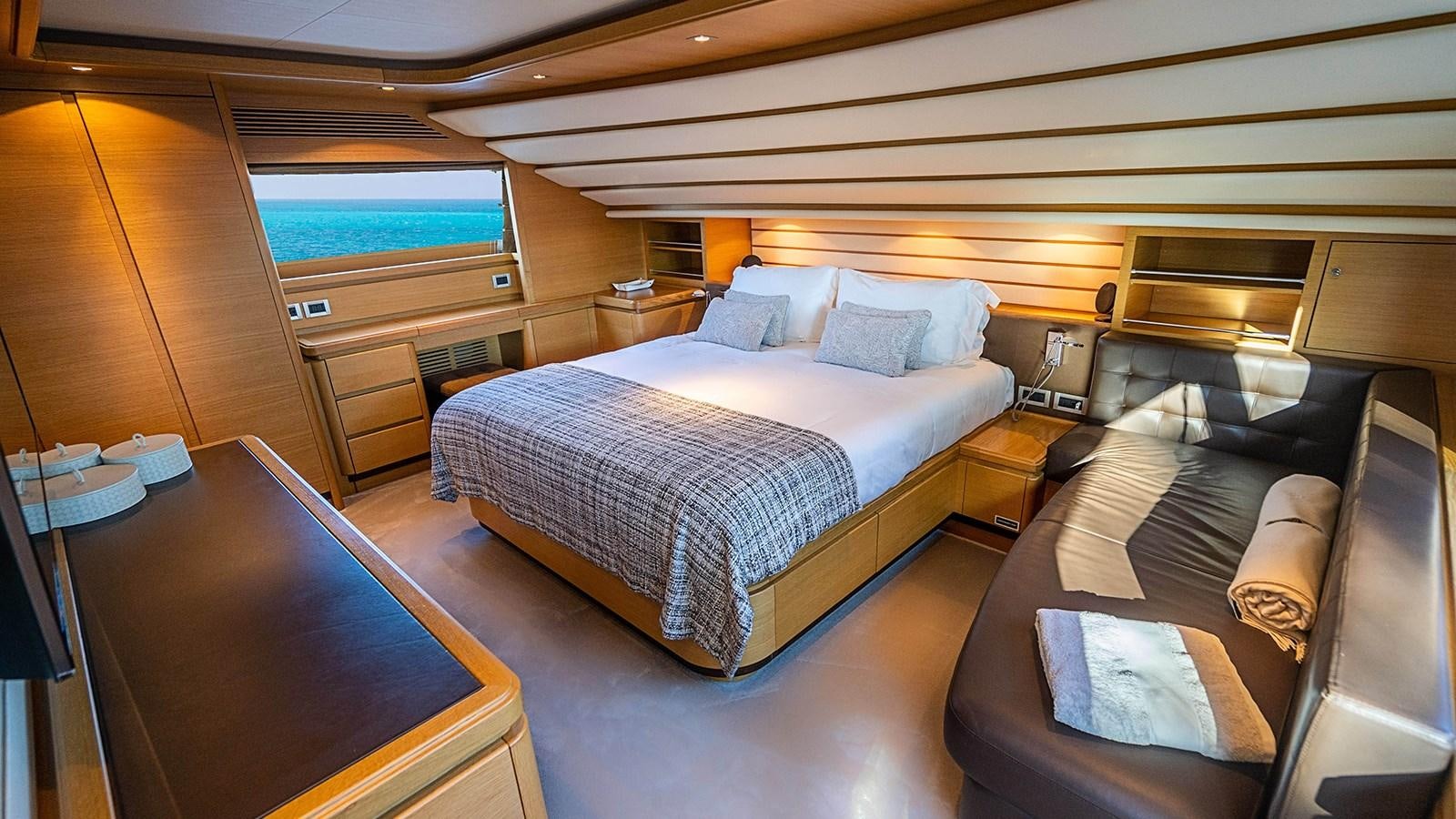 a room with a bed and a couch aboard PATRON Yacht for Sale