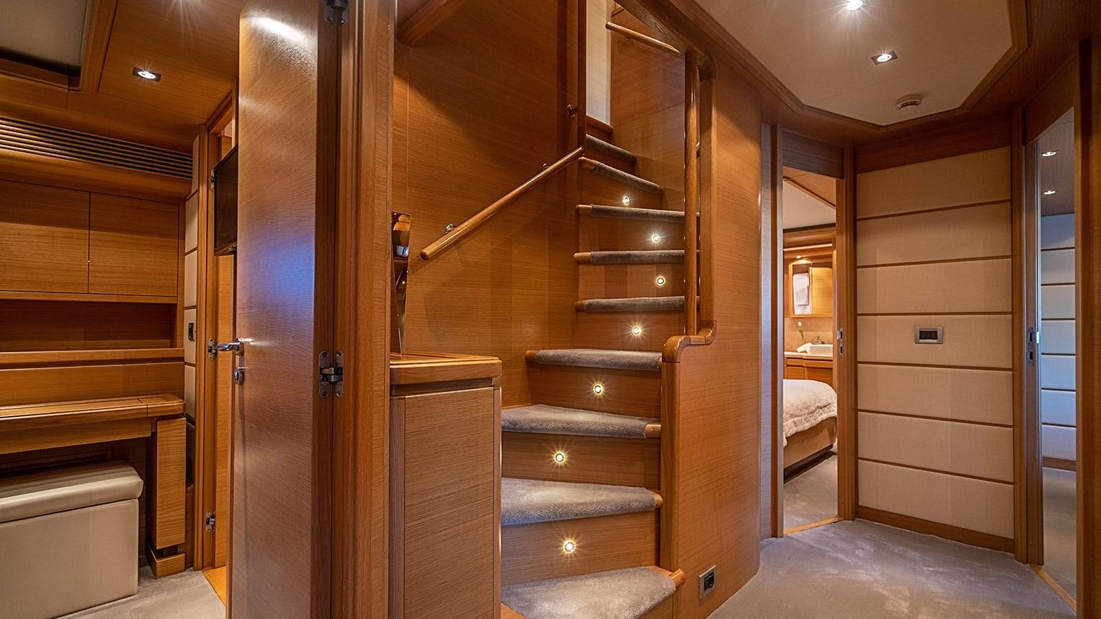 a room with wooden walls and a wood staircase aboard PATRON Yacht for Sale
