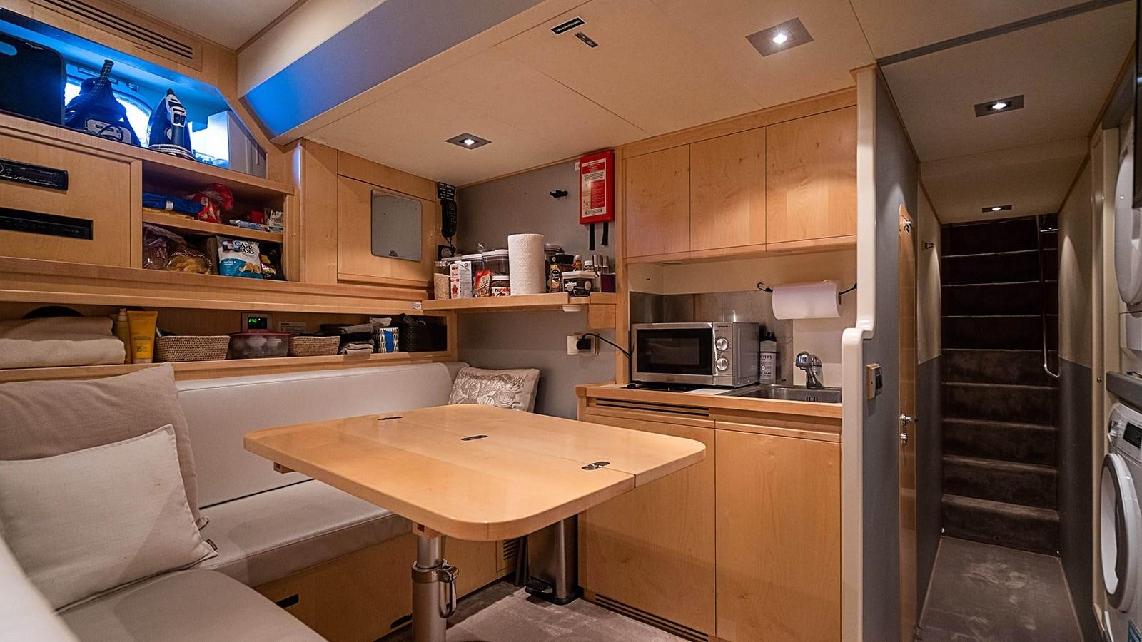 a kitchen with a table and a couch aboard PATRON Yacht for Sale
