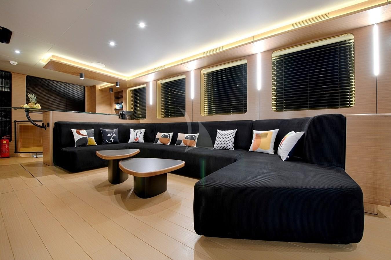a living room with a black couch aboard MITI ONE Yacht for Charter