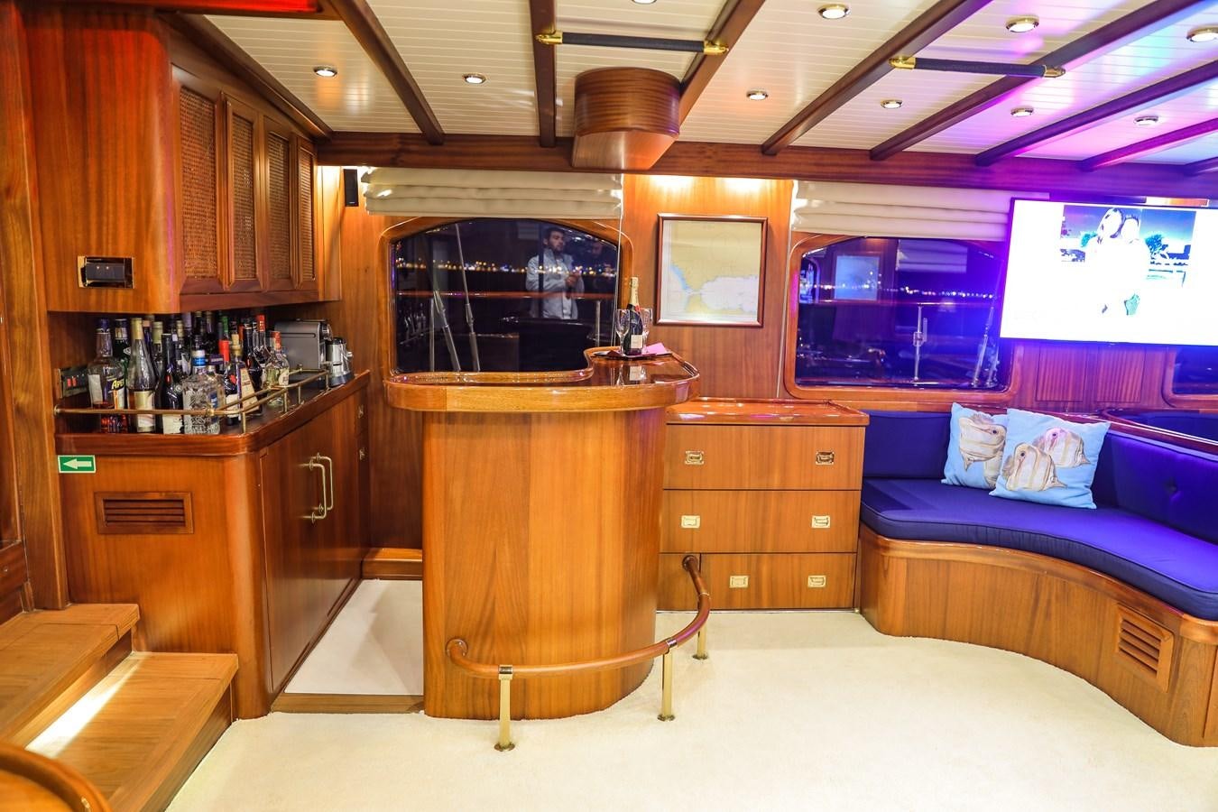 a bar with a bar and a couch in it aboard OFELIA Yacht for Sale