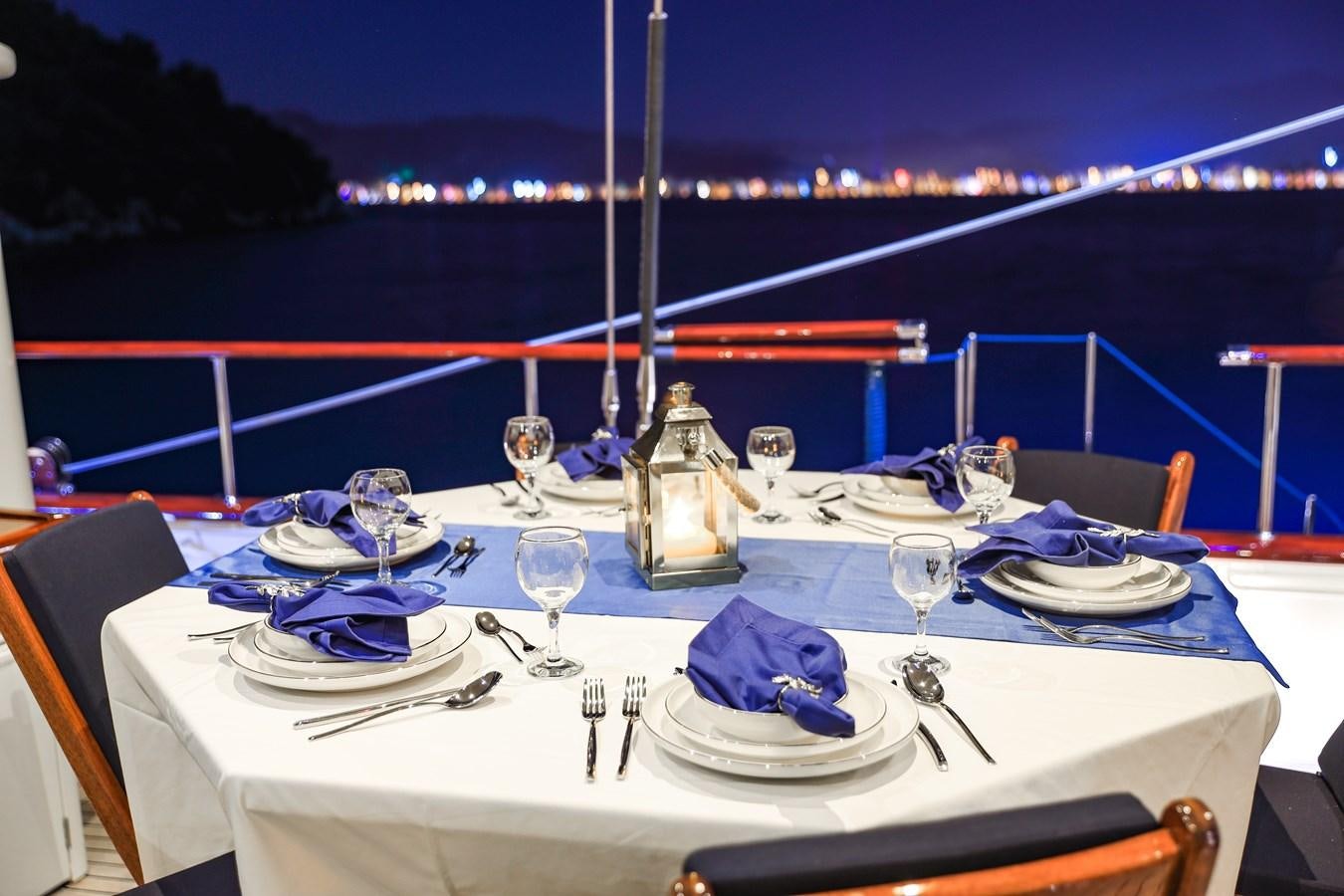 a table set with plates and silverware on a boat aboard OFELIA Yacht for Sale