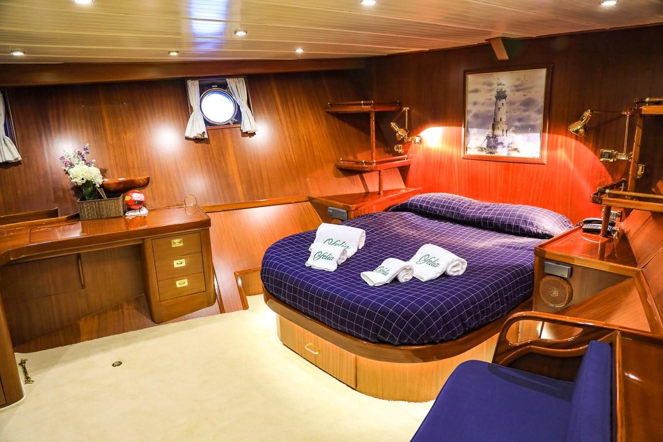 a bedroom with a bed and desk aboard OFELIA Yacht for Sale