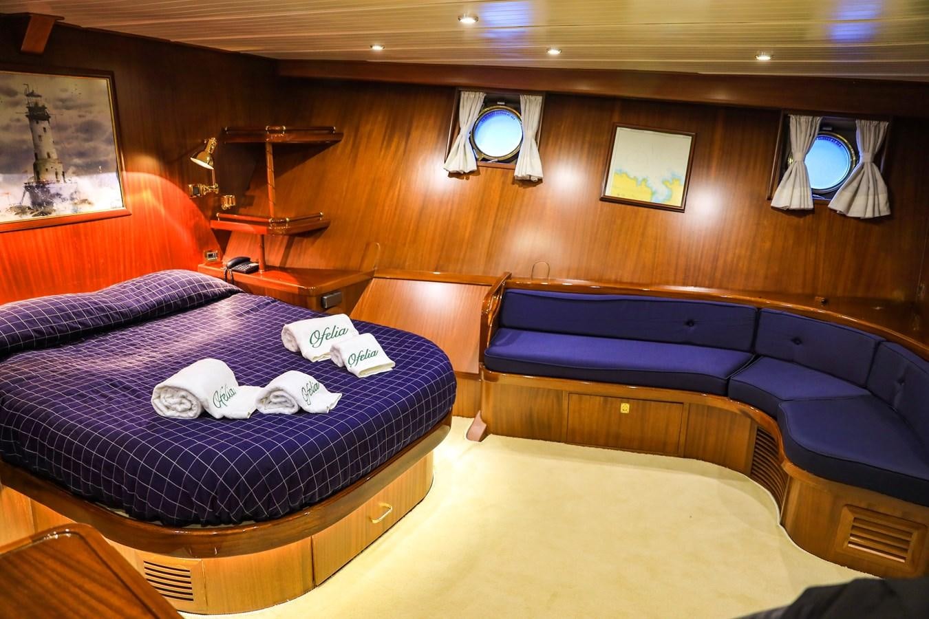 a room with a bed and a desk aboard OFELIA Yacht for Sale