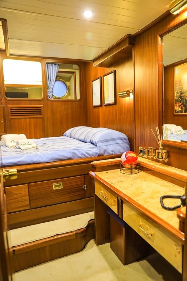 a bedroom with a bed and a desk aboard OFELIA Yacht for Sale