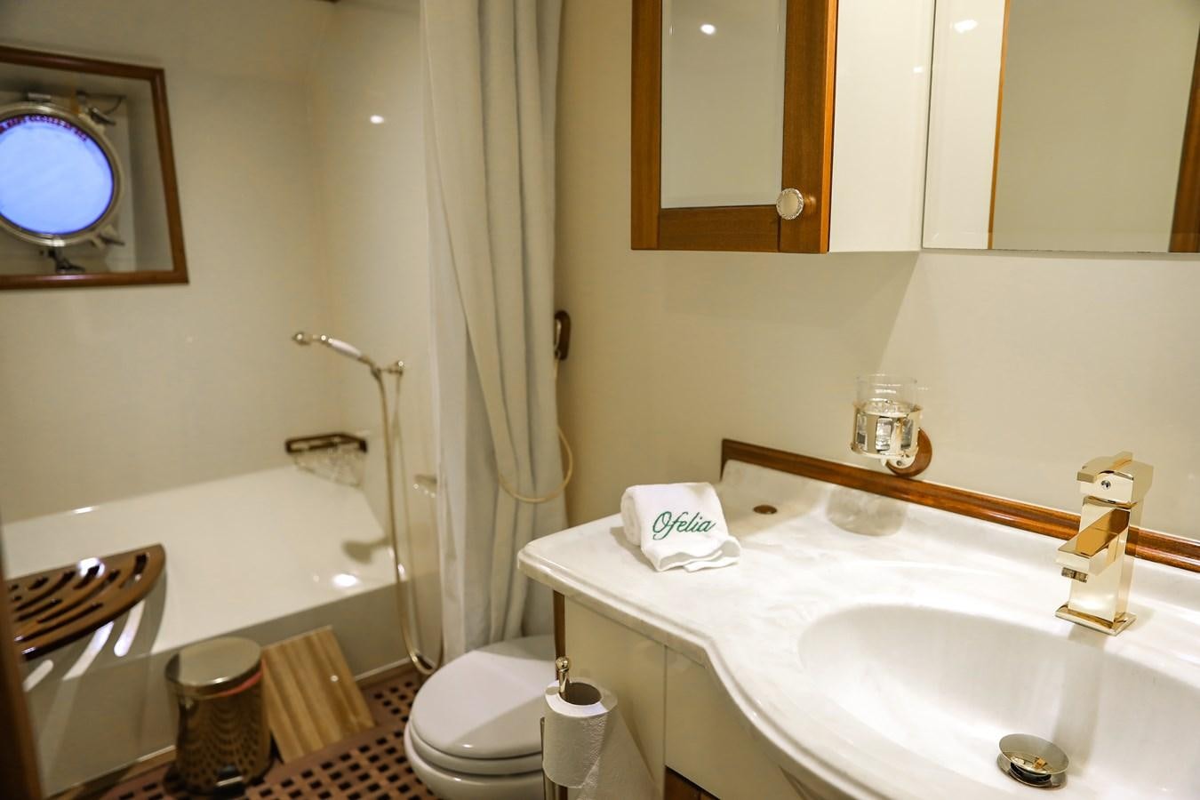 a bathroom with a tub sink and toilet aboard OFELIA Yacht for Sale