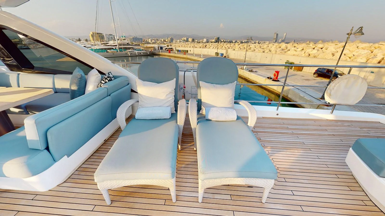 a deck with chairs and a view of a city aboard HALLELUJAH Yacht for Charter