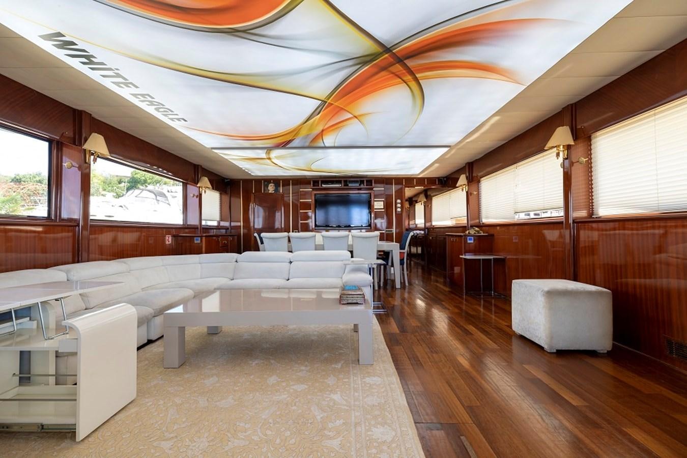 a room with a large room with many seats and a table aboard DENIZ Yacht for Sale
