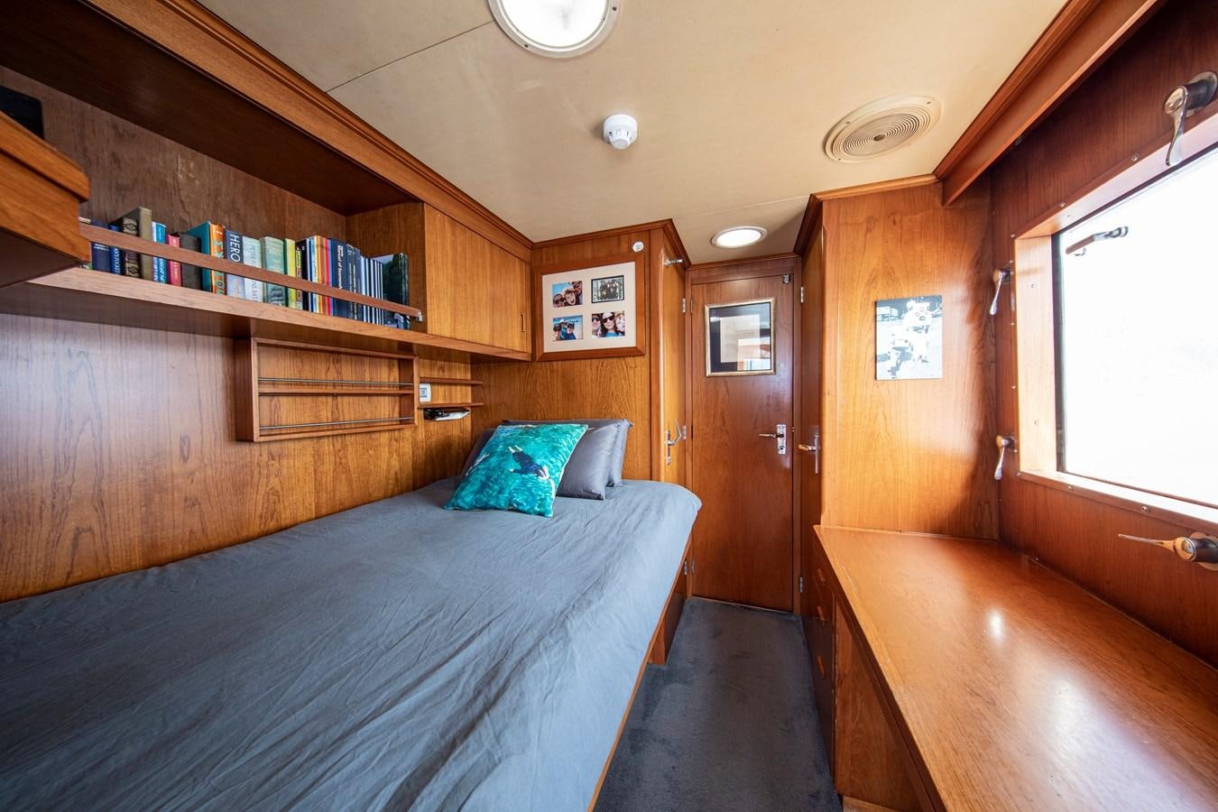 a room with a bed and a bookcase aboard MONACO Yacht for Charter