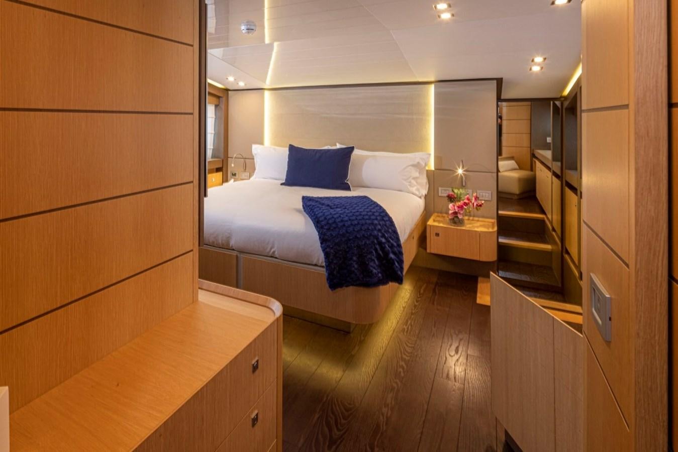 a bedroom with a bed and a desk aboard SOL SHINE Yacht for Sale