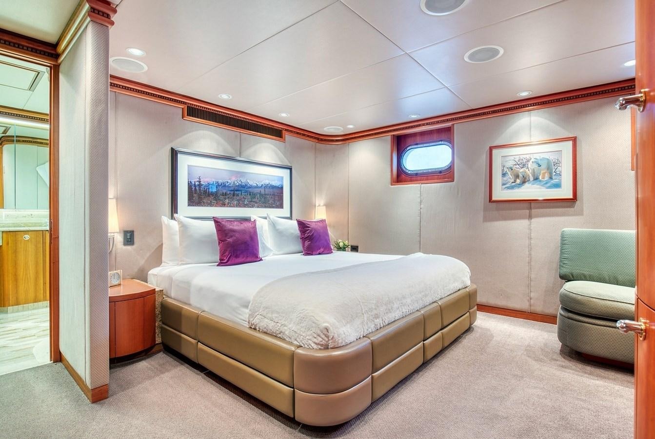 a bedroom with a bed and a chair aboard ICE BEAR Yacht for Sale