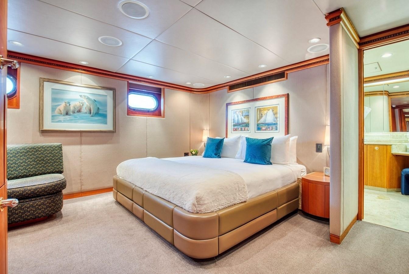 a bedroom with a bed and a chair aboard ICE BEAR Yacht for Sale