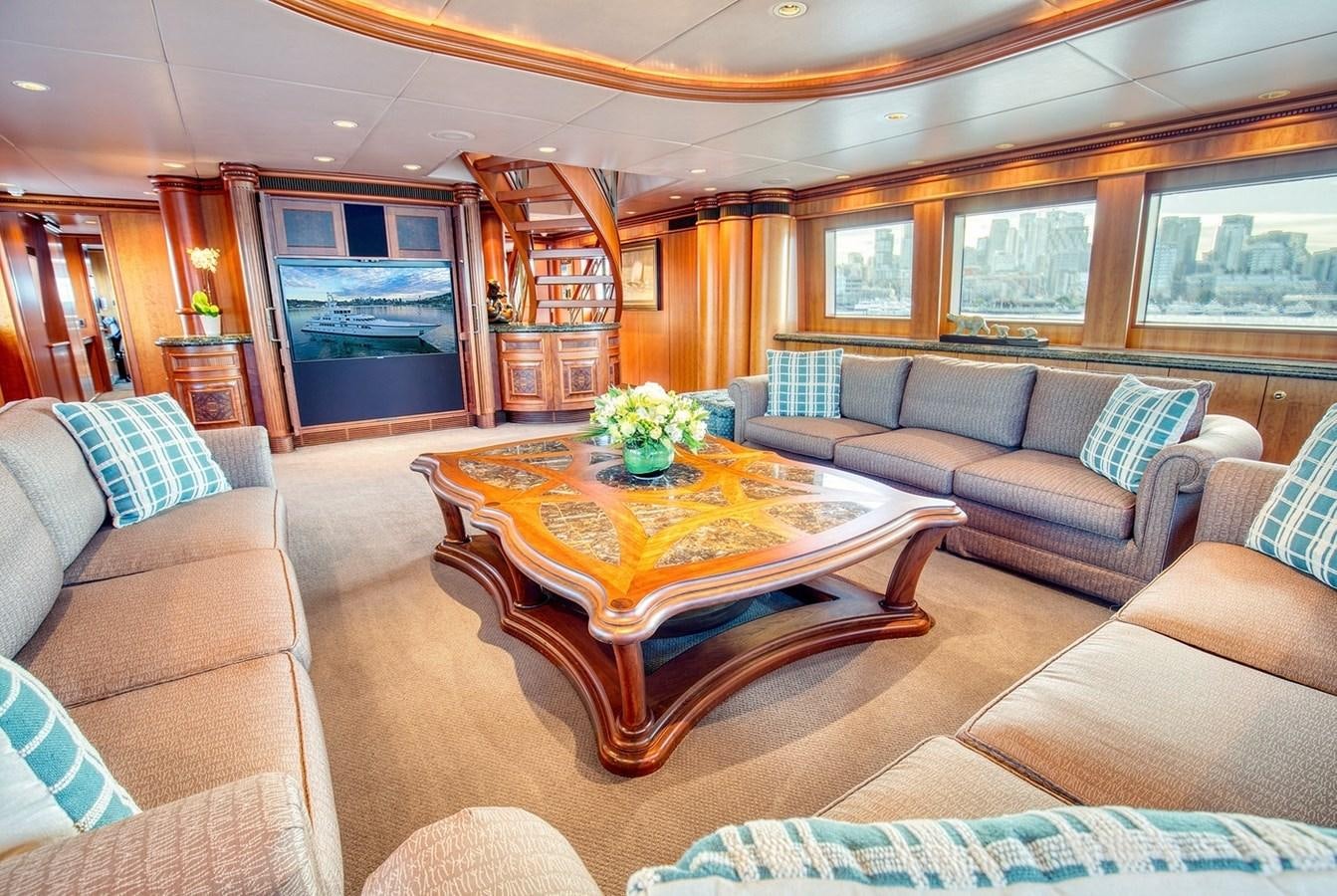 a living room with a table and couches aboard ICE BEAR Yacht for Sale