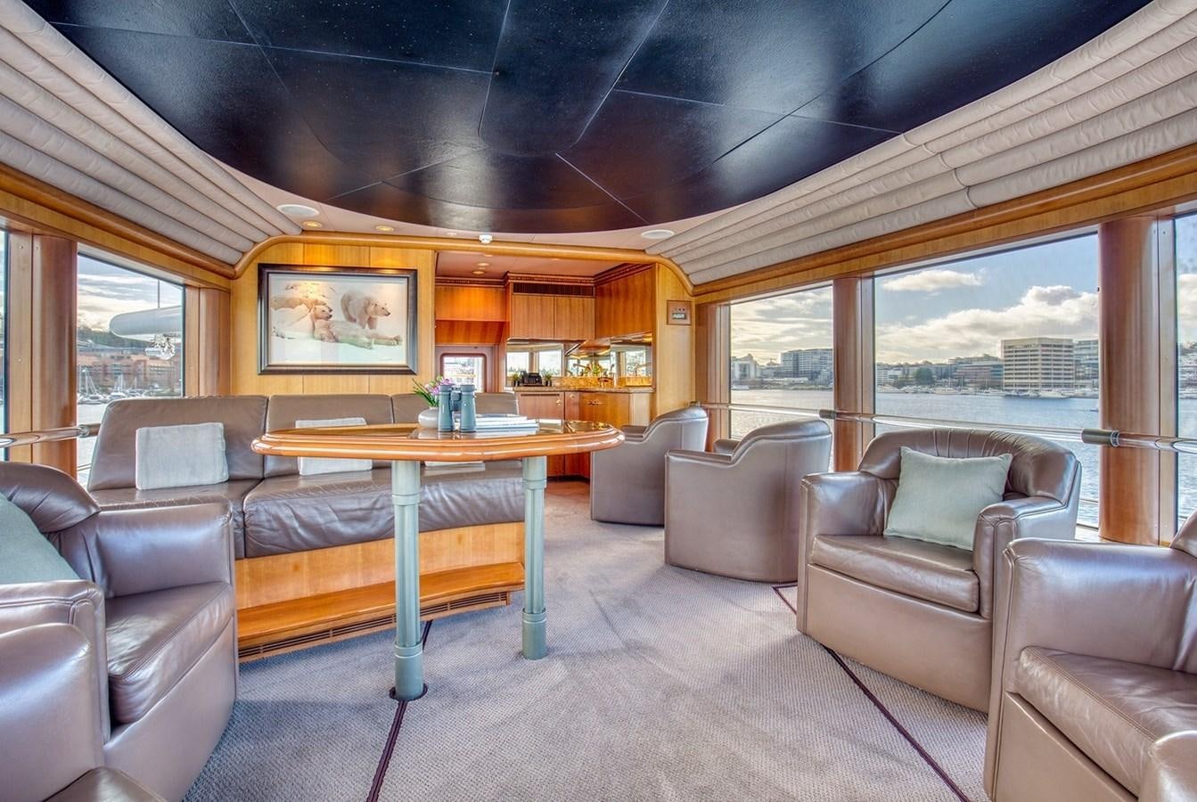 a living room with a table and couches aboard ICE BEAR Yacht for Sale