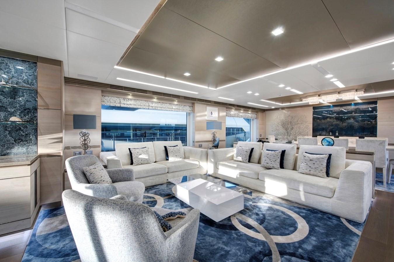 a large living room with white couches and a large window aboard CHARADE Yacht for Sale