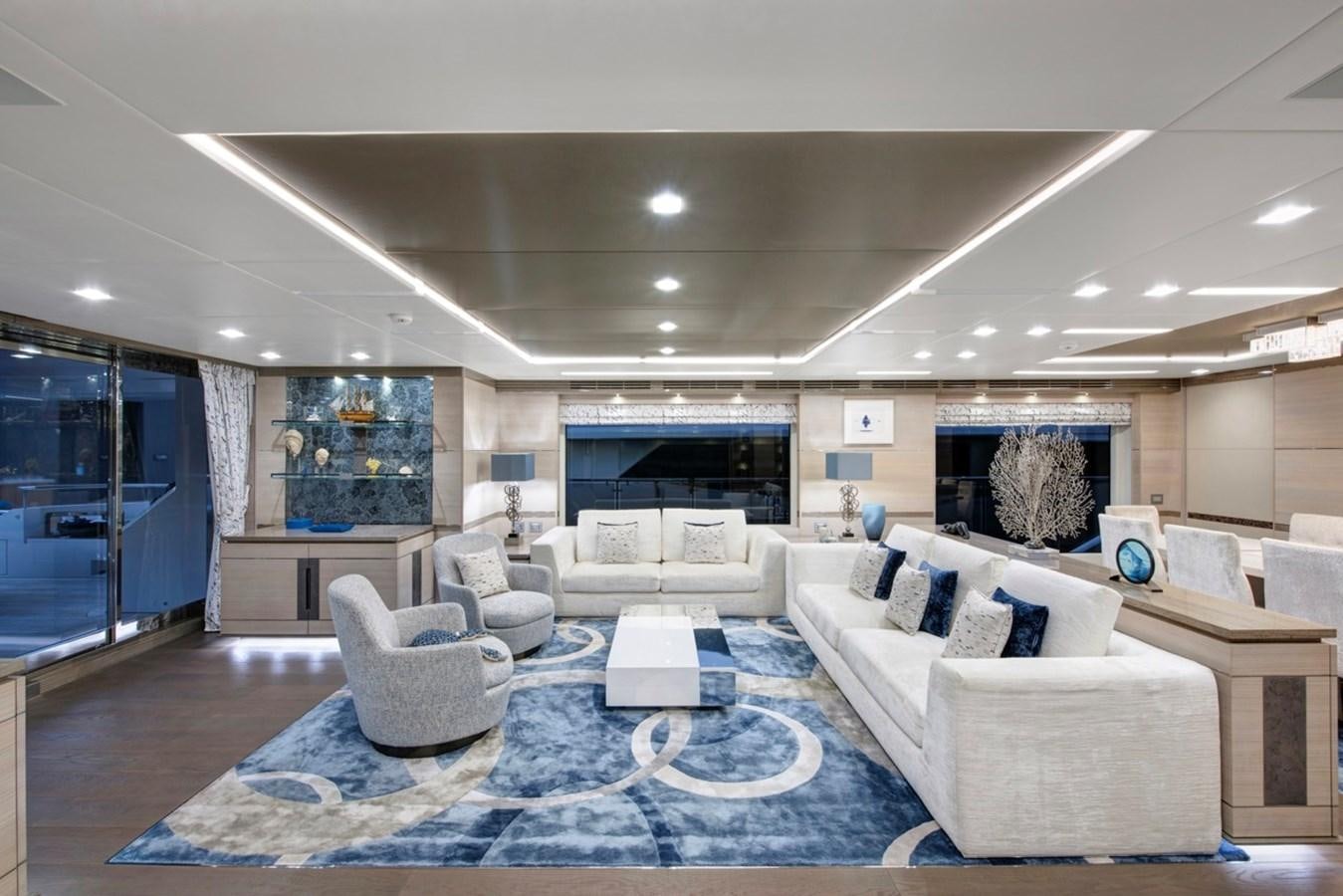 a large living room with white furniture aboard CHARADE Yacht for Sale