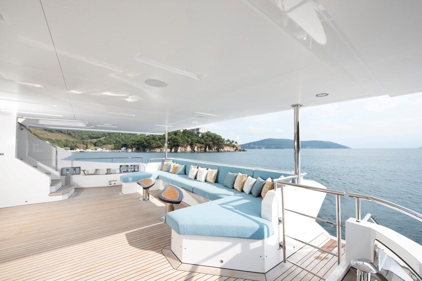 a deck with a pool and lounge chairs on it aboard CHARADE Yacht for Sale