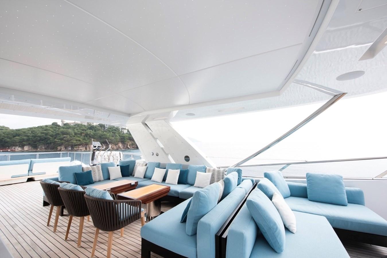 a room with a group of chairs and a table and a pool aboard CHARADE Yacht for Sale