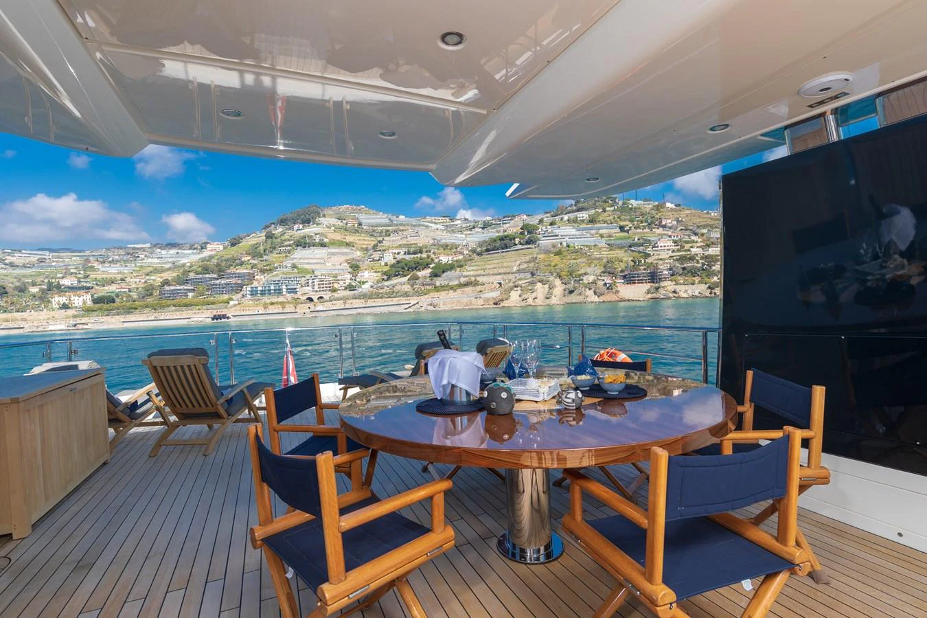 a table set for a meal on a deck overlooking a city aboard LADY MARISA Yacht for Sale
